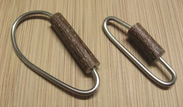 Wellensittich-Bild: Verschiedene Größen und Formen sind natürlich jederzeit möglich. Die Größe richtet sich in der Hauptsache danach, wie dick der Ast oder der Gitterstab ist, an dem der Karabiner befestigt werden soll. Dabei ist es wichtig zu beachten, dass die Größe der Karabiner-Öffnung und die der Holzperle entsprechend angepasst werden muss.
